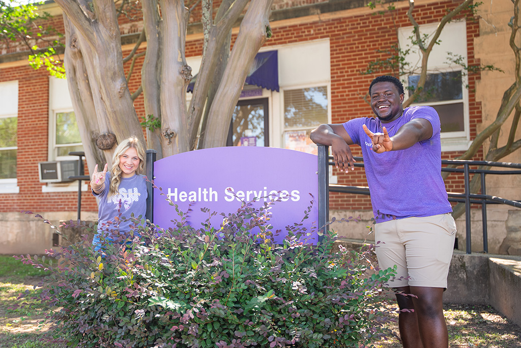 NSU students posing near sign at Health Services