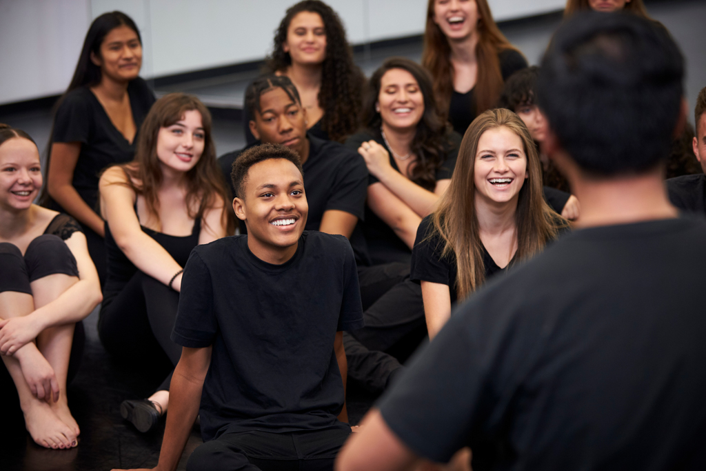 A group of students listen attentively to an instructor speaking