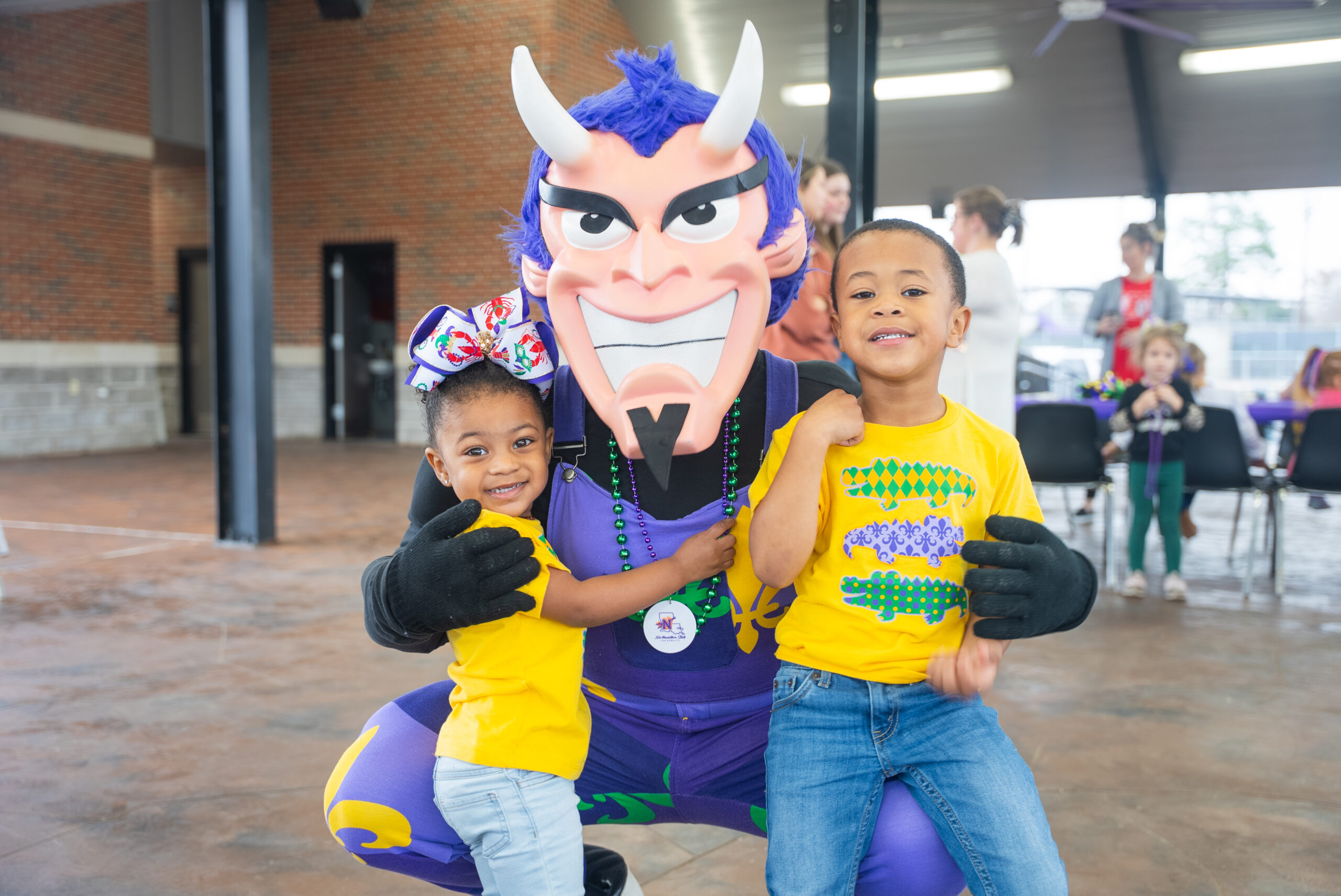 NSU mascot poses with young children