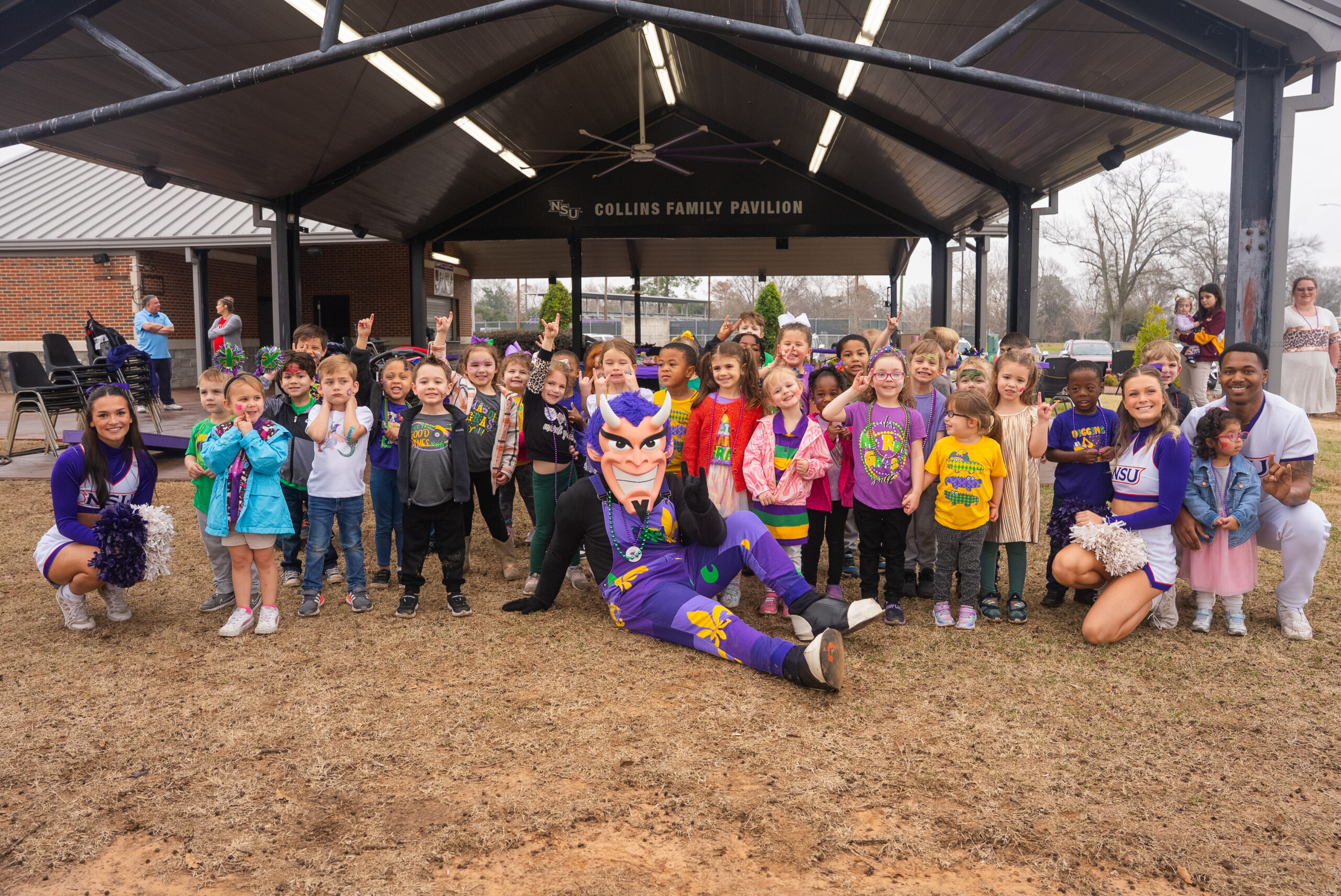NSU mascot poses with young children