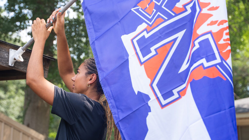 NSU Junior Makenna Tryon, a Lady Demon volleyball player from Waller, Texas, joined fellow student volunteers in distributing NSU flags and signage to Natchitoches homes and businesses July 30.