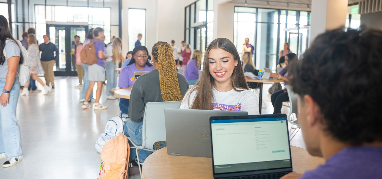 Students inside Alost Hall on laptops