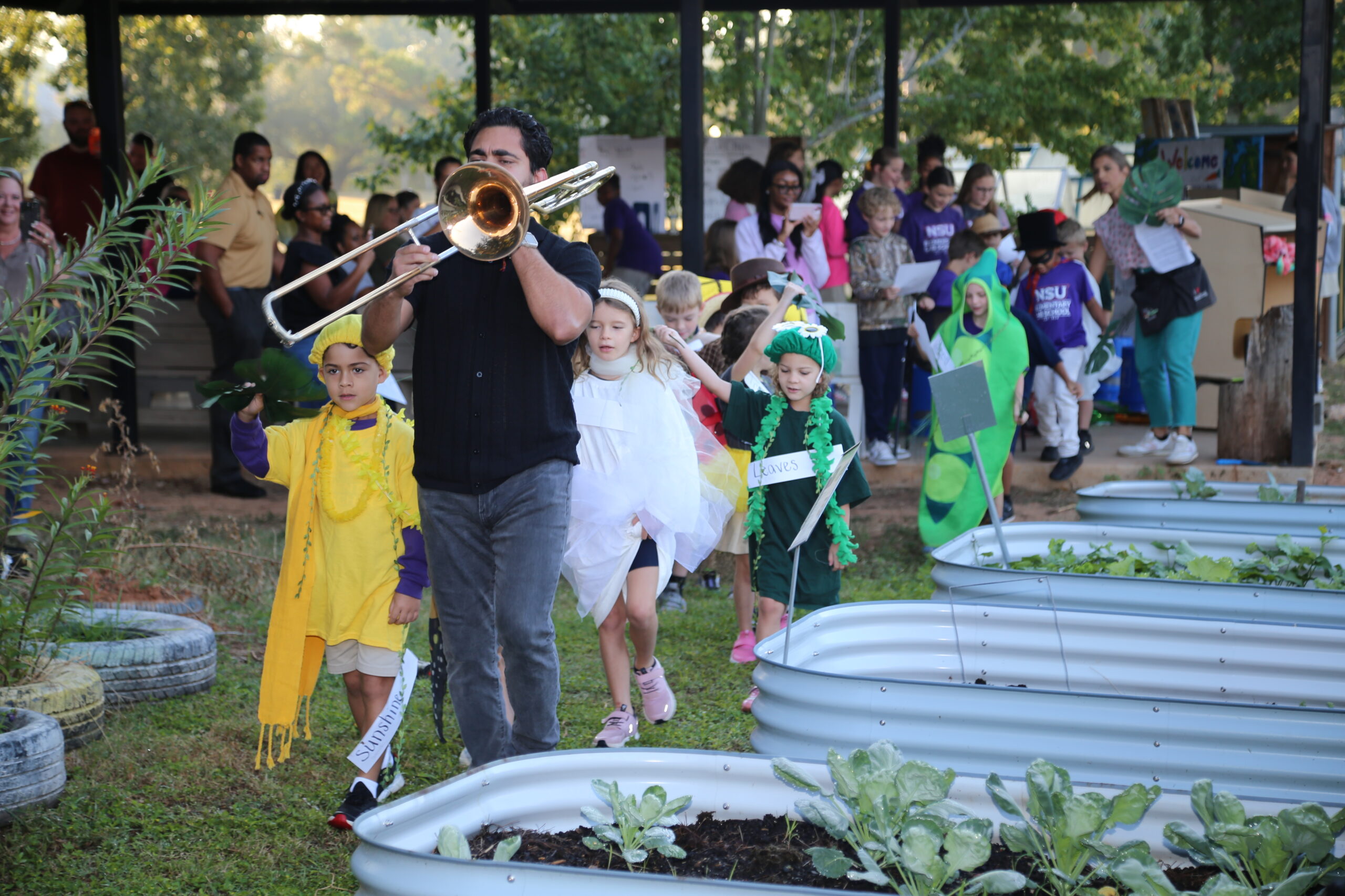 Gabriel Camargo Patron, with his dad Carlos on trombone, led NSU Elementary Lab first graders in a second line through the school garden to the tune of “When the Seeds Get Planted Snug.”