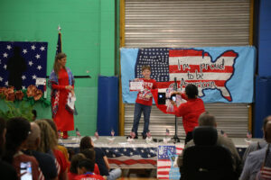 Emmitt Maggio was winner of the Veterans Day essay contest. 4-H Club sponsor Lisa Wiggins, right, presented the award.
