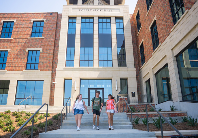 Students walking down stairs of Alost Hall on the campus of Northwestern State University