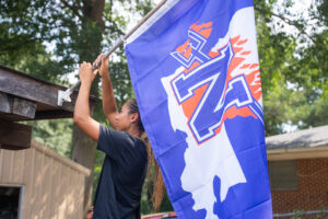 NSU Junior Makenna Tryon, a Lady Demon volleyball player from Waller, Texas, joined fellow student volunteers in distributing NSU flags and signage to Natchitoches homes and businesses last year as part of the 2025 Proud to Be Purple campaign.