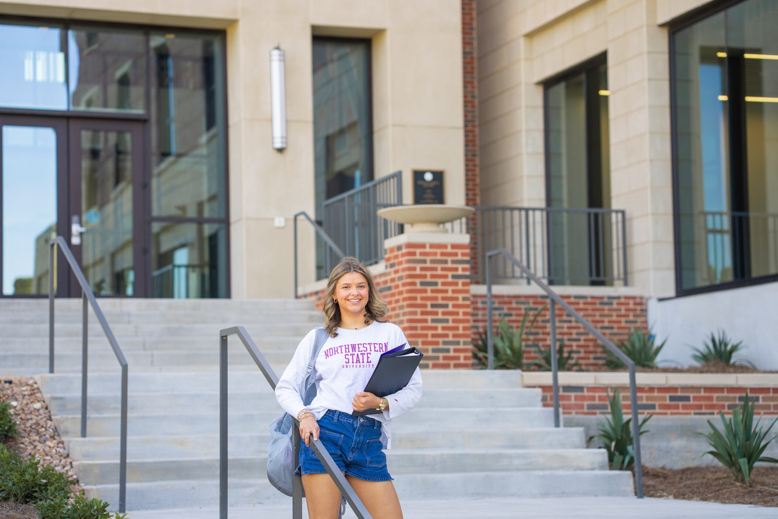 student standing in front of Alost Hall