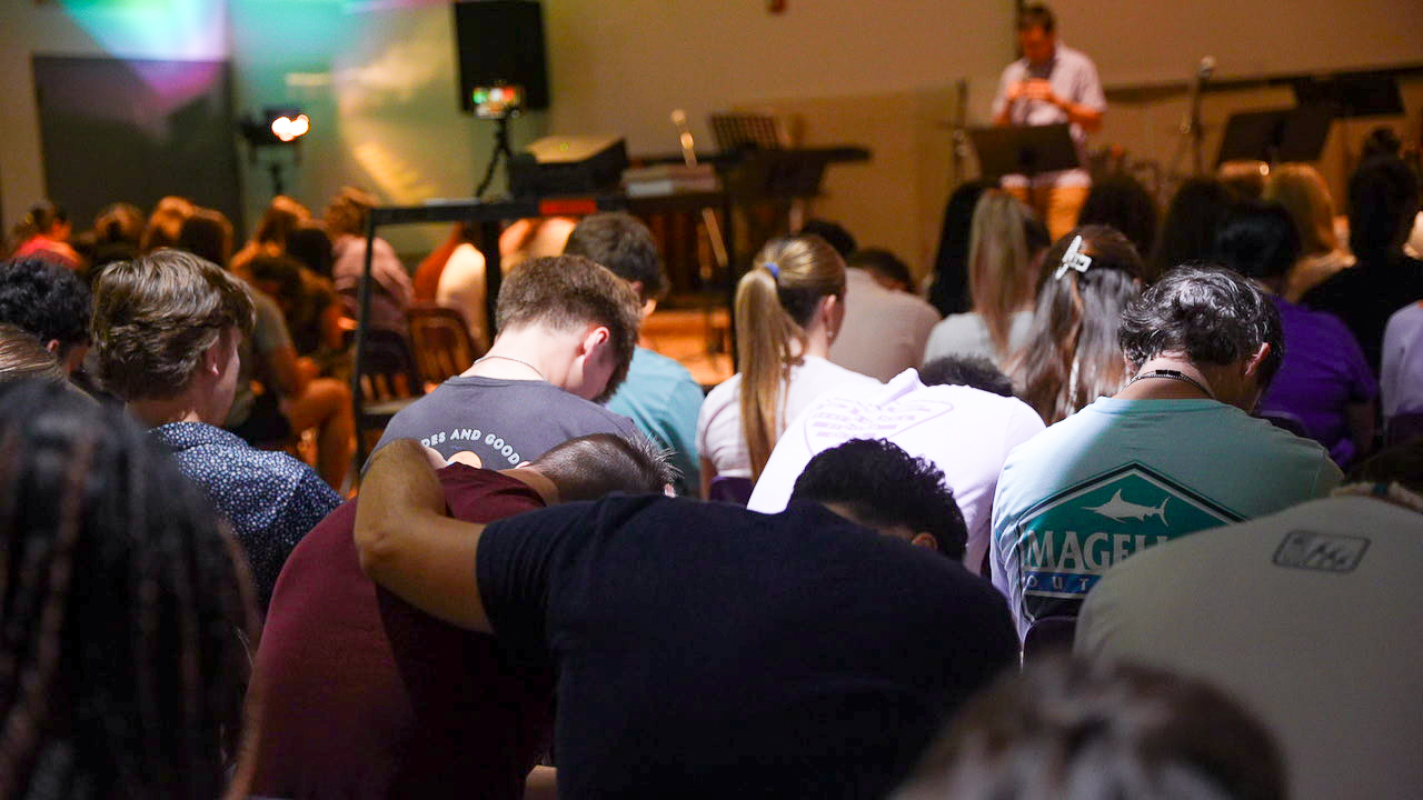 Students pray together during a Baptist Collegiate Ministry gathering at NSU.