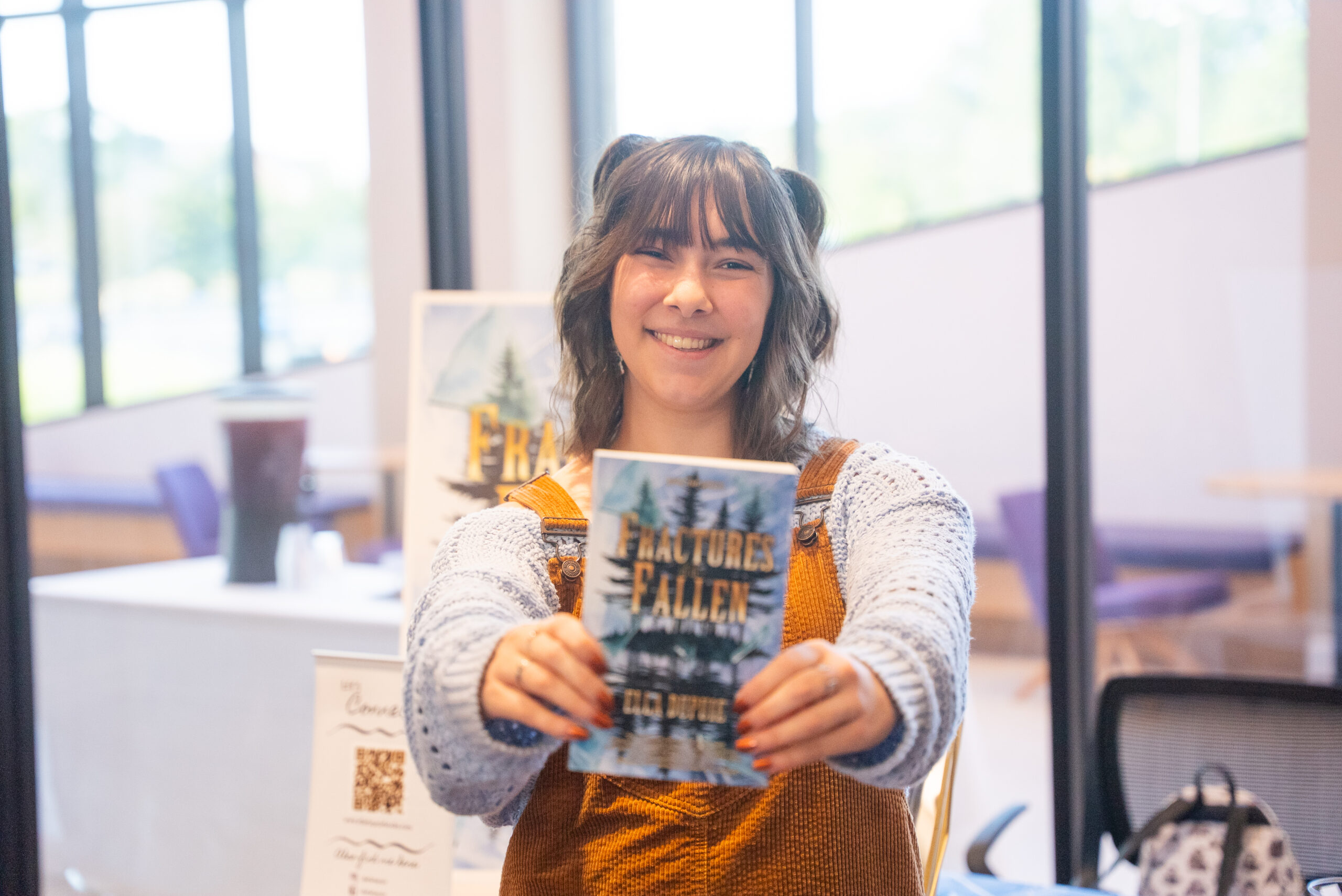 NSU student holding the book that she wrote