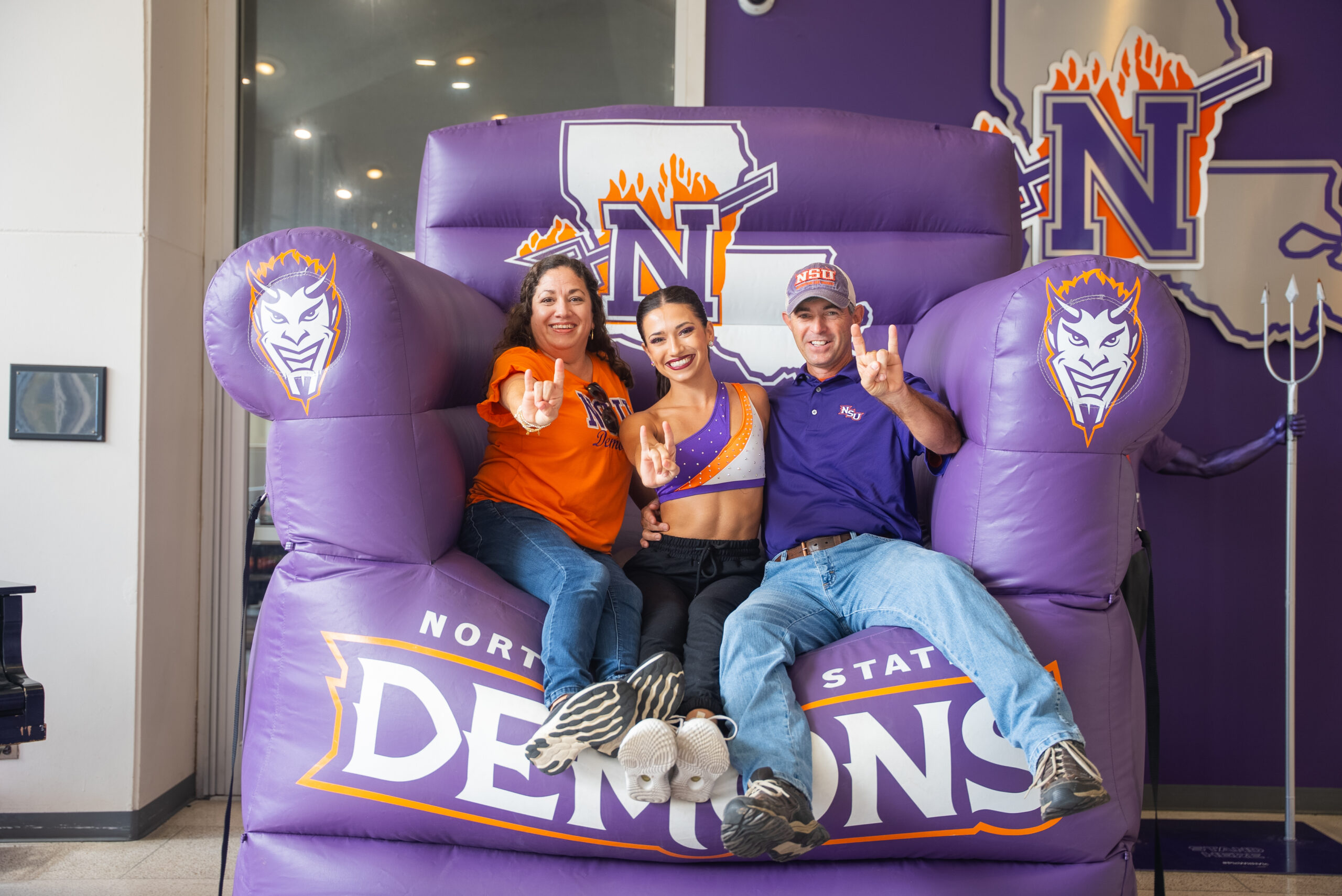 NSU student sitting on a purple chair with her family