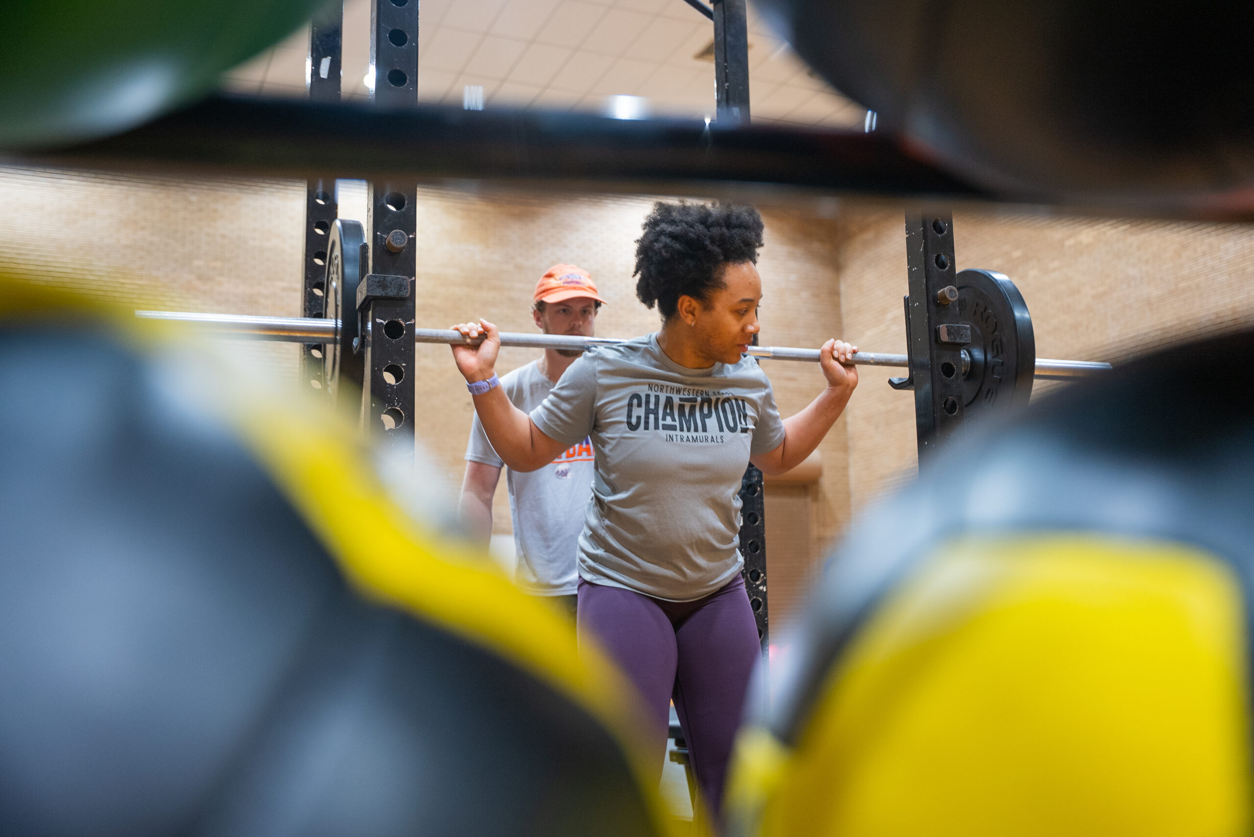 student lifting weights in a workout room