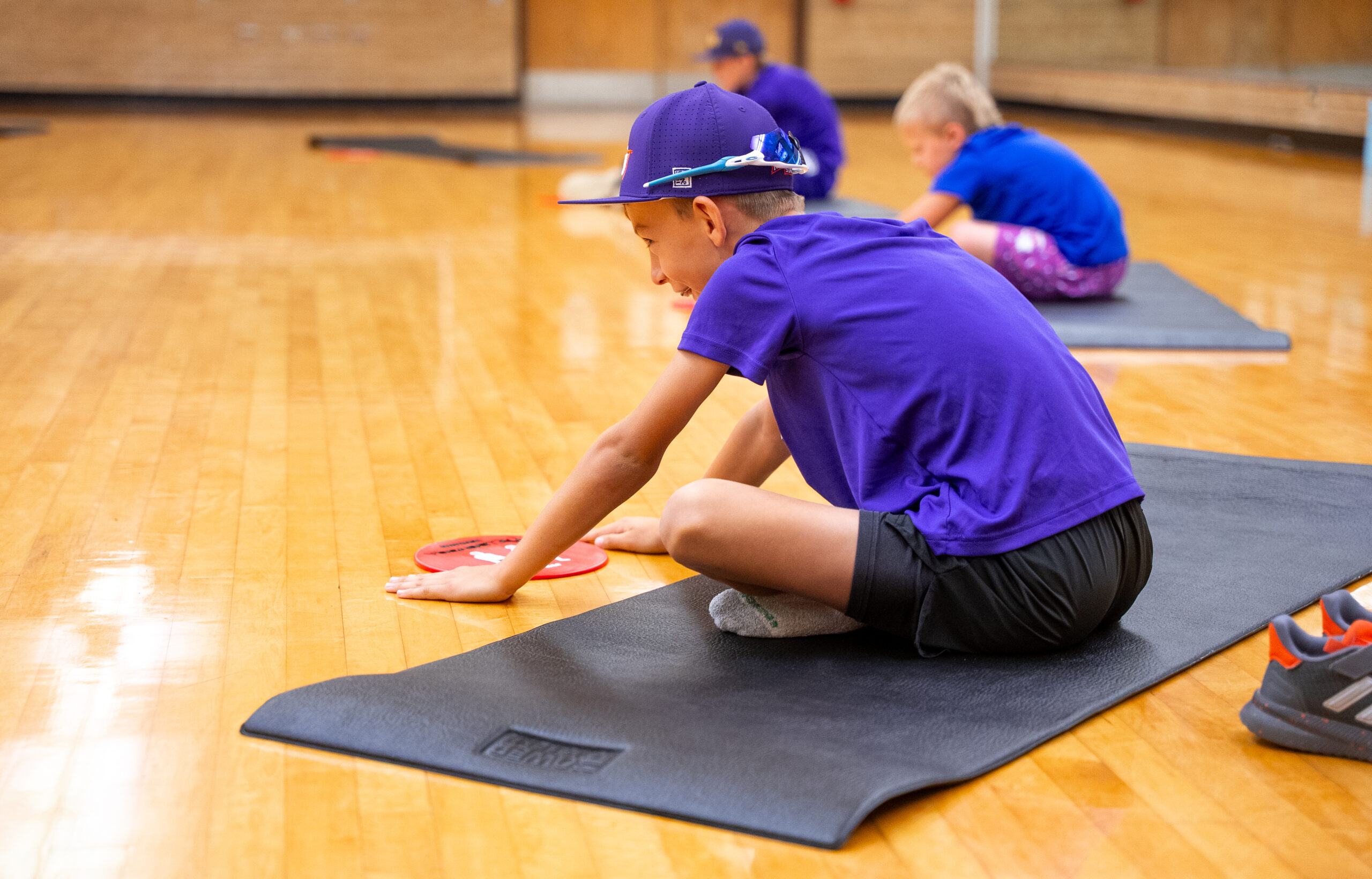 A camper participates in a flexibility exercise during Northwestern State University's Sport Agility & Nutrition Camp.