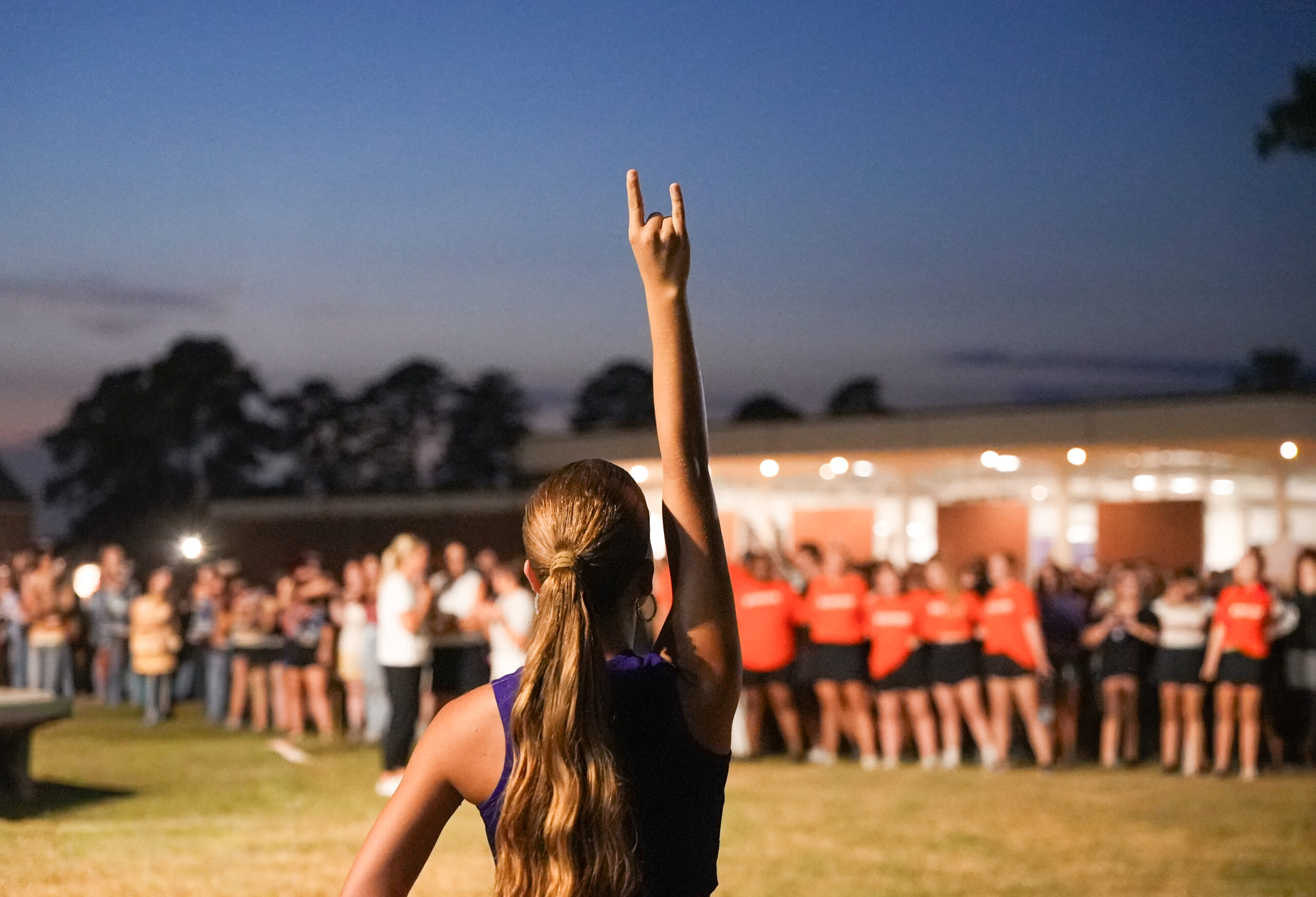 A Demon Dazzler holds up her fork during the alma mater at the Demons Come Out at Night Pep Rally.