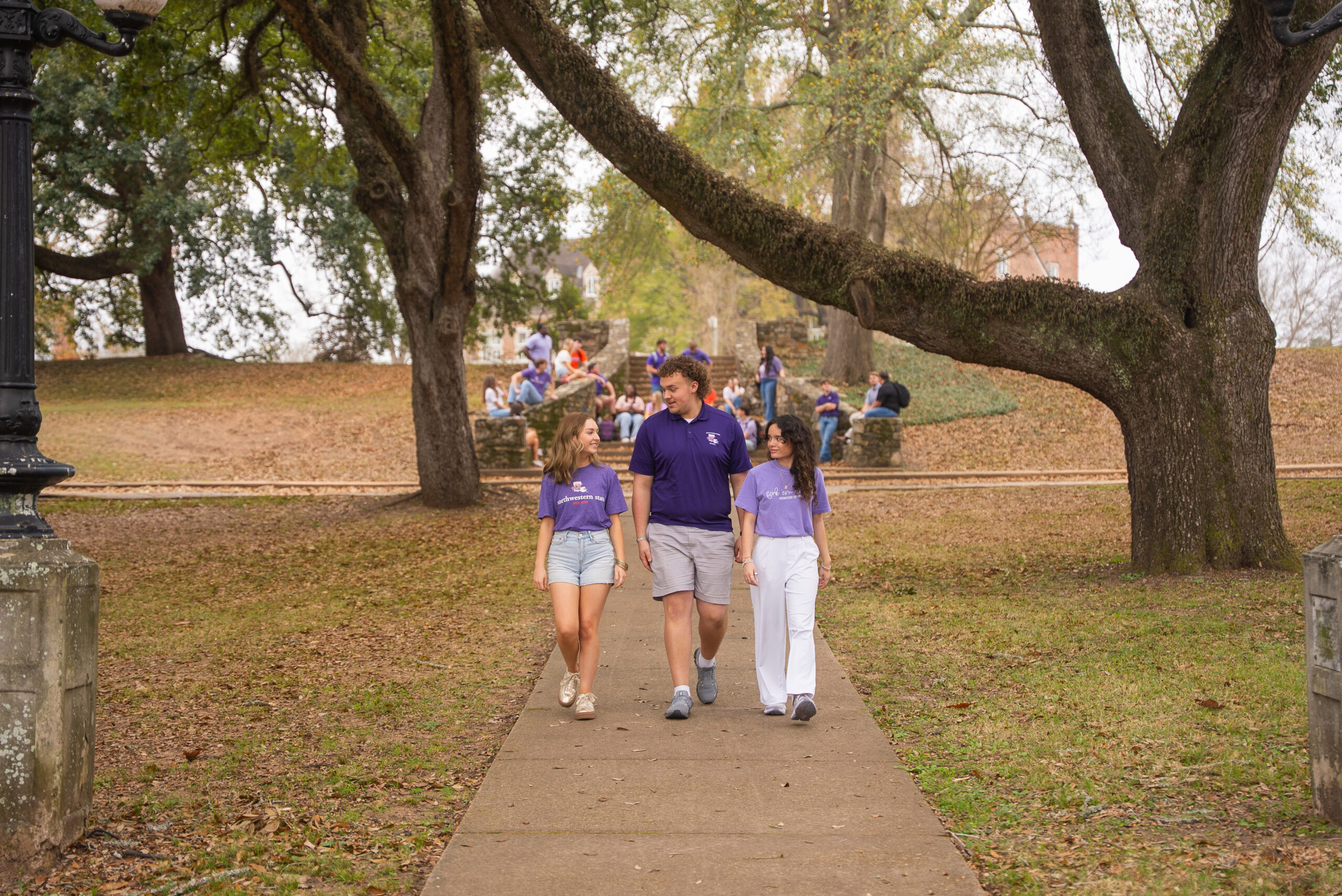 NSU students walking on campus under trees