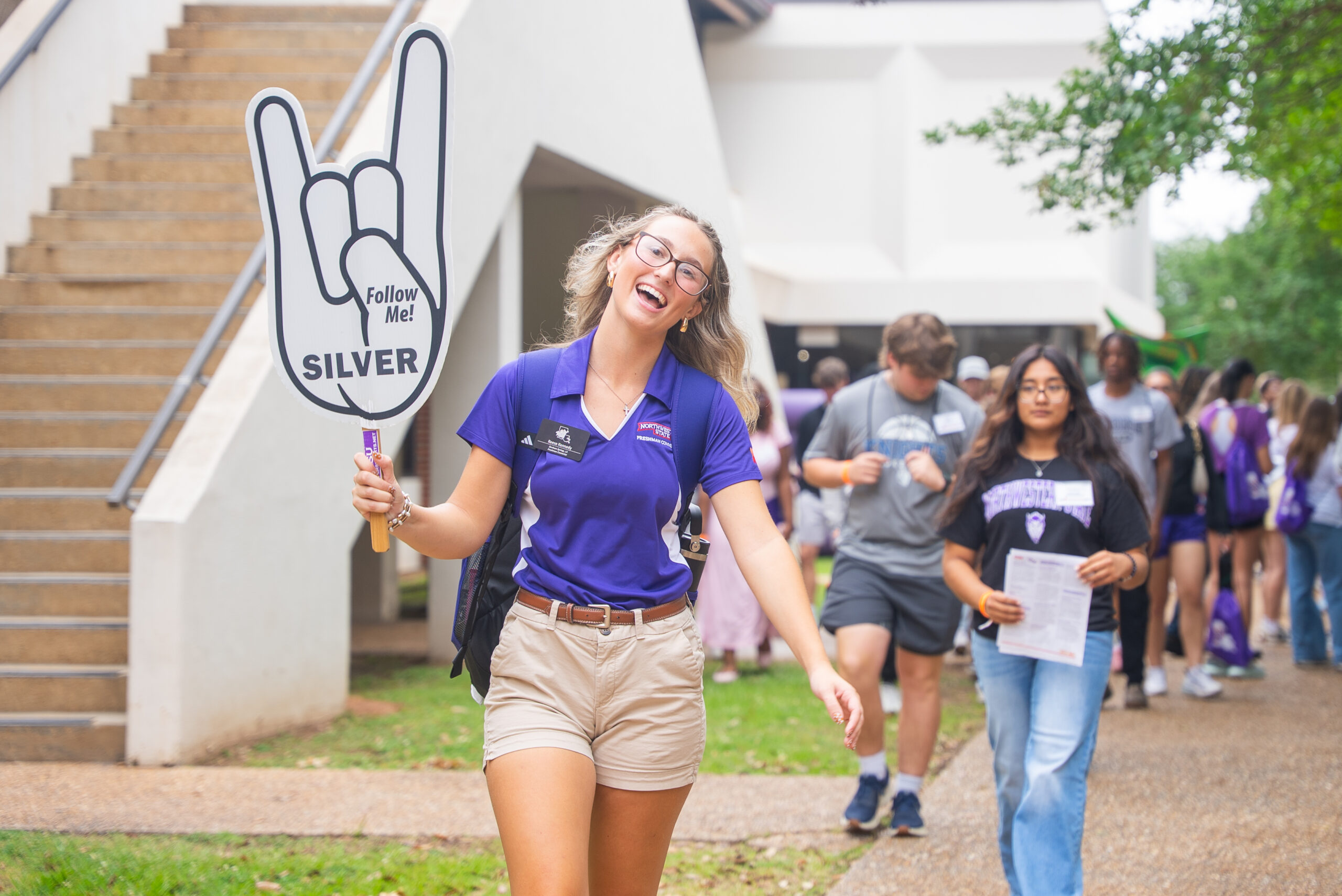 NSU Freshman Connector walking with color group sign