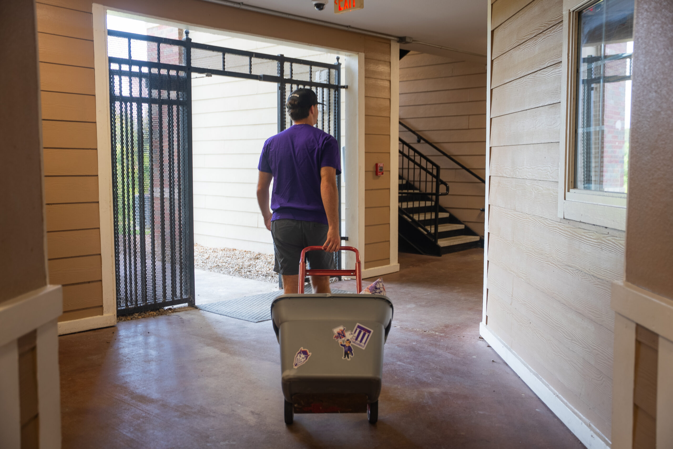 NSU student with a dolly and a box moving into campus housing