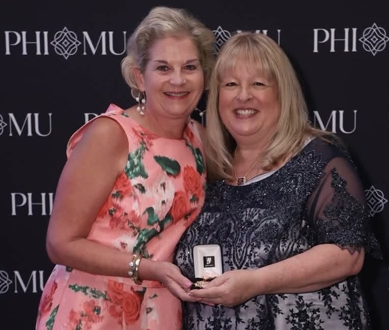 NSU alumna Emilyn Matthews Horton, left, received Phi Mu Fraternity’s Outstanding Alumna Achievement Award for Contribution to the Community at the organization’s 2026 National Convention in Atlanta. The award is presented to one alumna every two years from Phi Mu’s worldwide membership of more than 200,000 women. Lynn Storlien McGraw, national president of Phi Mu, presented the award.