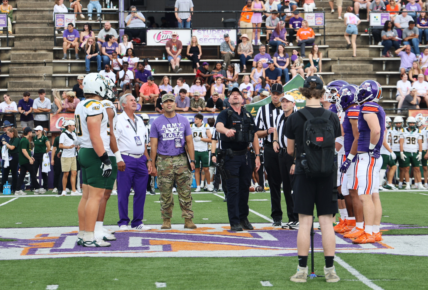 Staff Sergeant (Ssgt) Retired, Donterry Colombel, center, did the coin toss prior to NSU’s football game against Southeastern Sept. 26. In addition to players and game officials, he was accompanied by NSU President James Genovese and Captain Armando Lopez, head of NSU’s Department of Military Science.