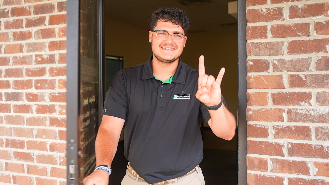 Northwestern State University student Jude Oliva greets customers while completing a summer internship with Enterprise Mobility.
