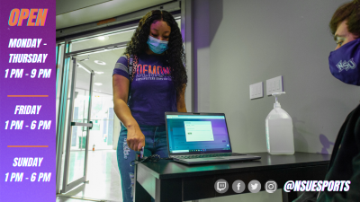 A masked female student swipes her ID at the NSU Esports check-in desk attended by a masked male student.