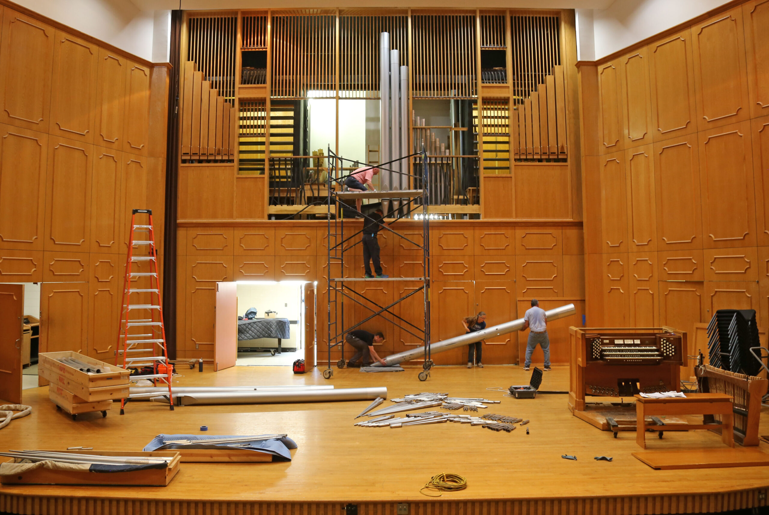 Organ Master and President of Reuter Organ Company JR Neutel, top of scaffold, worked with four assistants to manually remove the largest pipe, which weighs about 300 pounds, from NSU’s famed pipe organ. The instrument’s components are now on their way to Lawrence, Kansas, where they will be cleaned and upgraded, to be reinstalled at NSU later this summer. Giving opportunities to support the organ renovation are available at https://northwesternstatealumni.com/organ-restoration/.